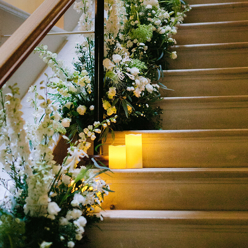 Stairwell in Kirtlington Park with candles and flowers decorated for a wedding